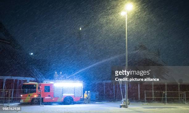 Members of the fire service spray snow from a circus tent, which threatened to collapse under the weight of the snow, in Hanover, Germany, 10...