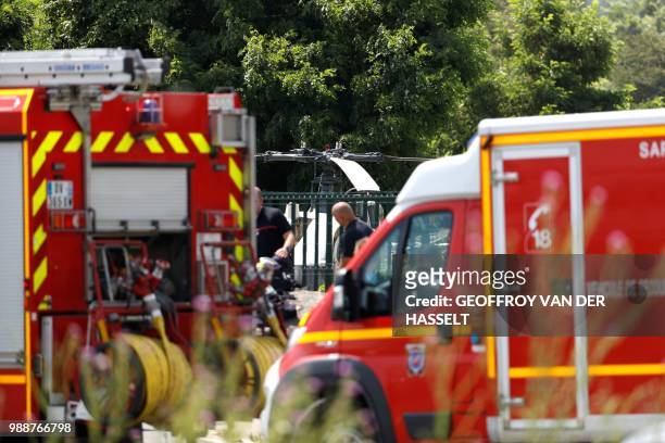 This picture taken on July 1, 2018 in Gonesse, north of Paris shows firefighters standing near the site where French robber Redoine Faid abandoned a...