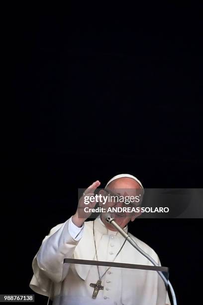 Pope Francis waves to the crowd from the window of the apostolic palace overlooking St Peter's square during the Sunday Angelus prayer, on July 1,...