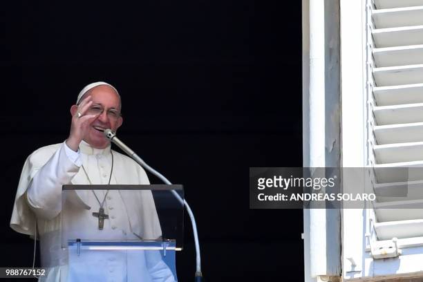 Pope Francis waves to the crowd from the window of the apostolic palace overlooking St Peter's square during the Sunday Angelus prayer, on July 1,...