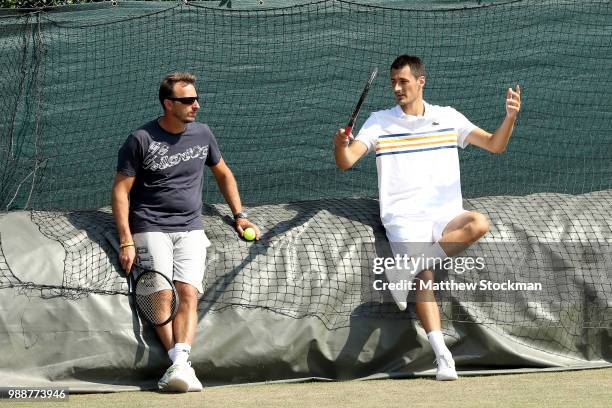 Bernard Tomic of Australia cools down while practicing on court during training for the Wimbledon Lawn Tennis Championships at the All England Lawn...