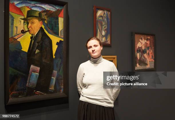 Curator Liis Paehlapuu stands next to a self protrait by Jaan Vahtra at the exhibition 'The Savages of Germany. Die Bruecke and Der Blaue Reiter...