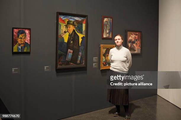 Curator Liis Paehlapuu stands next to a self protrait by Jaan Vahtra at the exhibition 'The Savages of Germany. Die Bruecke and Der Blaue Reiter...