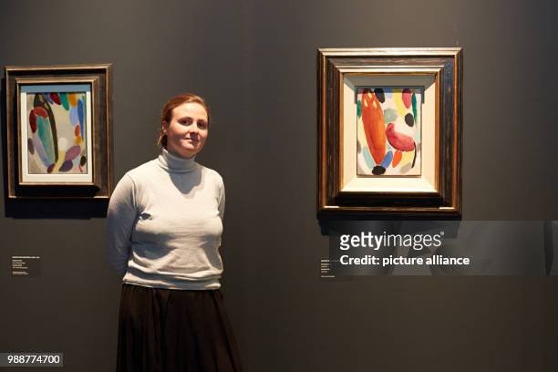 Curator Liis Paehlapuu stands next to the paintings 'Variation: Winter' and 'Variation: Fest' by Alexej von Jawlensky at the exhibition 'The Savages...