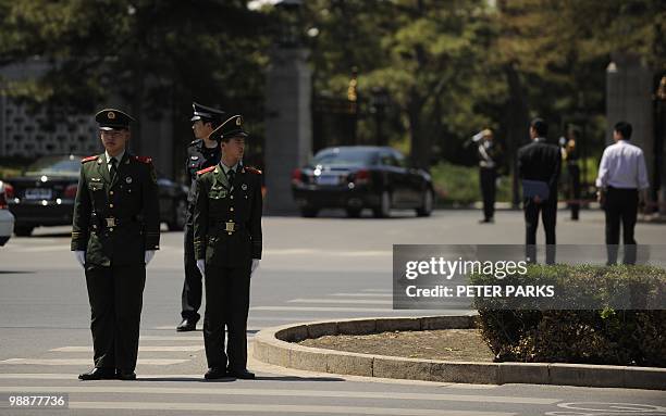 Police stand guard as a diplomatic motorcade enters the Diaoyutai State guest house in Beijing on May 6, 2010. North Korea's leader Kim Jong-Il is...