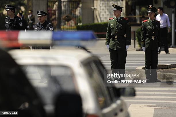 Police keep watch as a diplomatic motorcade enters the Diaoyutai State guest house in Beijing on May 6, 2010. North Korea's leader Kim Jong-Il is...