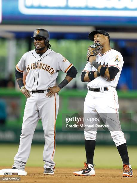 Alen Hanson of the San Francisco Giants talks with Starlin Castro of the Miami Marlins at Marlins Park on June 14, 2018 in Miami, Florida.