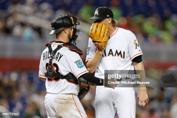 Adam Conley of the Miami Marlins talks with Bryan Holaday against the San Francisco Giants at Marlins Park on June 14, 2018 in Miami, Florida.