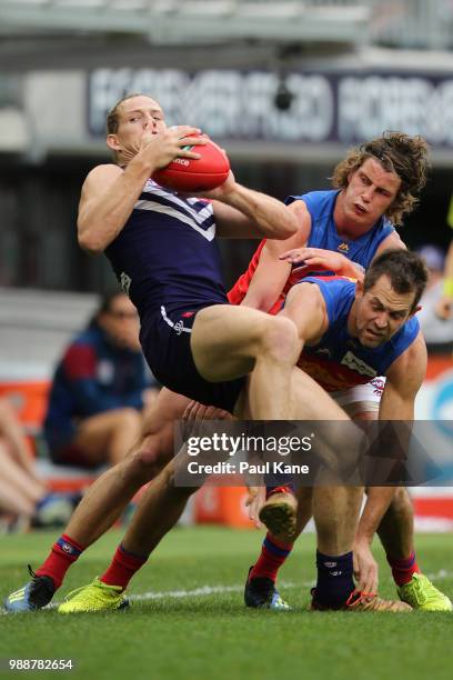 Nathan Fyfe of the Dockers marks the ball against Jarrod Berry and Luke Hodge of the Lions during the round 15 AFL match between the Fremantle...