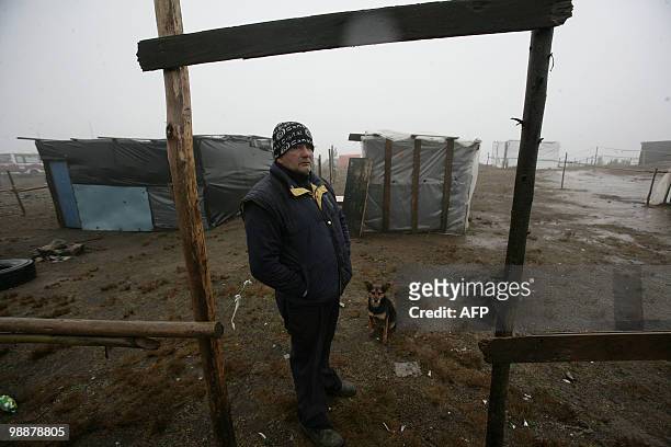 Refugee stand near emergency dwellings at Penco's port in Concepcion, some 500 km south of Santiago, May 5, 2010. The first autumn rains Wednesday...