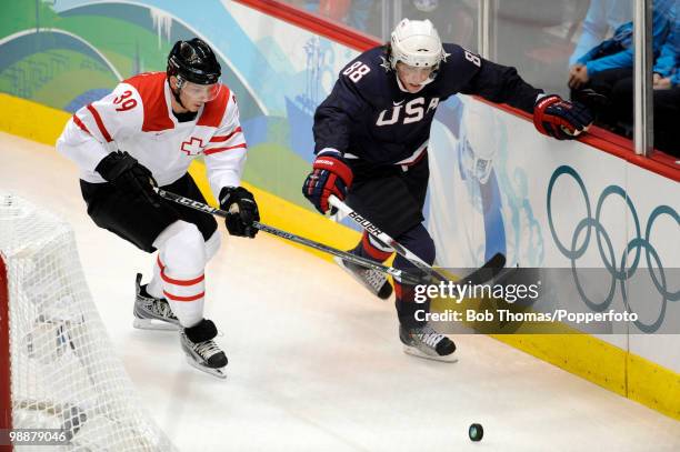 Raffaele Sannitz of Switzerland with Patrick Kane of the USA during the ice hockey men's preliminary game between the USA and Switzerland on day 5 of...