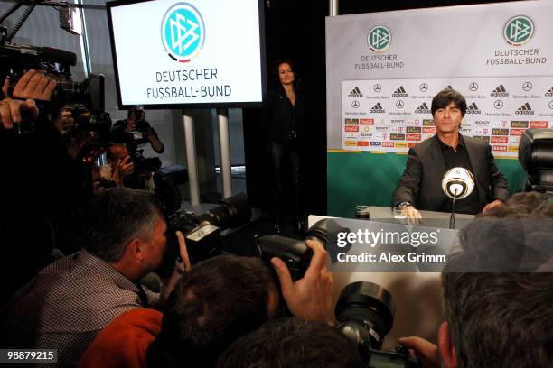 Joachim Loew, head coach of the German national football team, is surrounded by photographers during a press conference where he announces the...