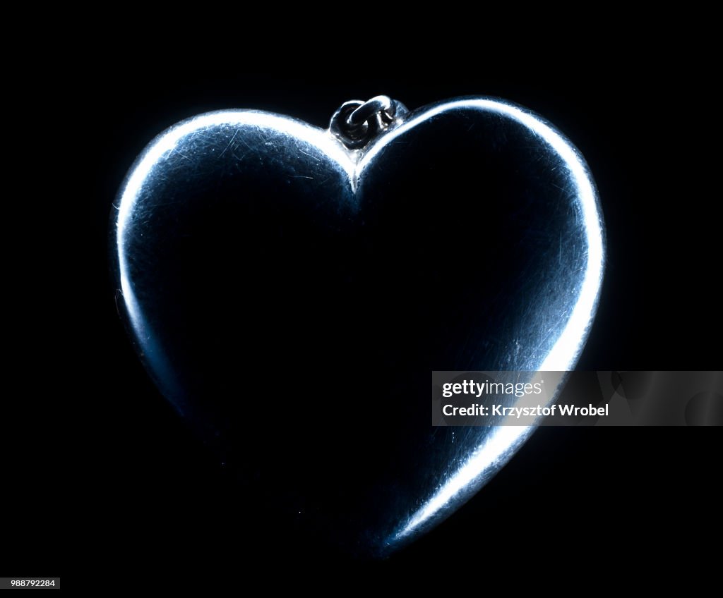 Heart shape emerging from a black background.