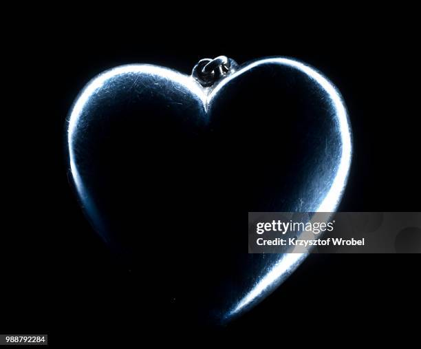 heart shape emerging from a black background. - animal internal organ stockfoto's en -beelden