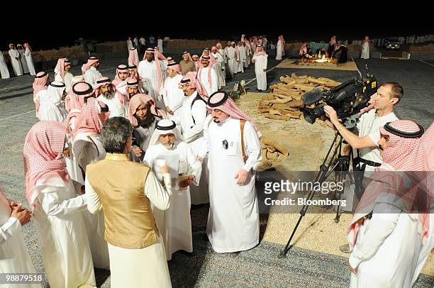 Saudi Prince Alwaleed bin Talal, bottom left, meets citizens who have lined up to ask for the Prince's assistance at the desert camp near Riyadh,...