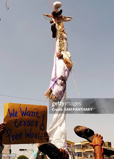 Indian citizens beat a hanged effigy of Mohammed Ajmal Amir Kasab with shoes as one jubilant holds a sign reading 'We Want terror free World" in...