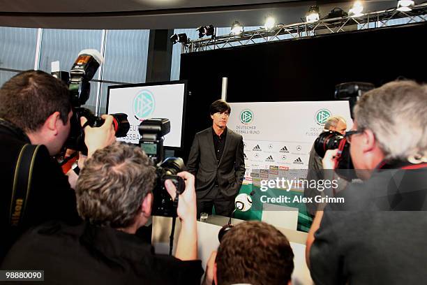 Joachim Loew, head coach of the German national football team, is surrounded by photographers during a press conference where he announces the...