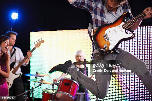 young man playing electric guitar jumping in air - pop music instruments stock pictures, royalty-free photos & images