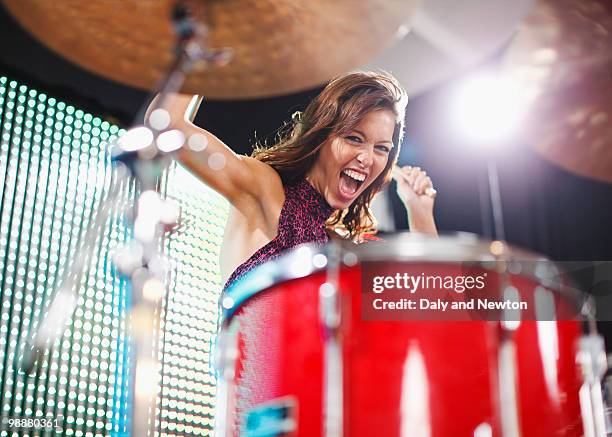 young woman playing drums - baterista fotografías e imágenes de stock