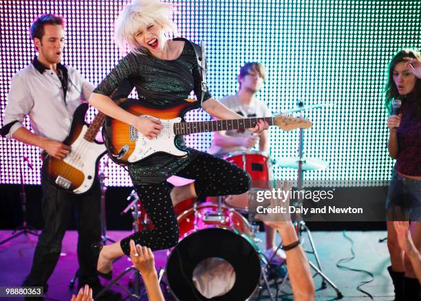 rock band performing on stage - pincer la corde photos et images de collection