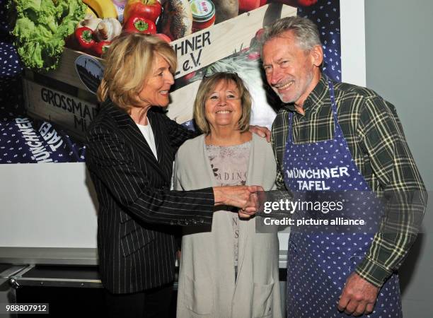 Hannelore Kiethe, president and founder of Munchner Tafel e.V. , greeting former national soccer player Paul Breitner and his wife Hildegard ahead of...