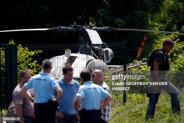 This picture taken on July 1, 2018 in Gonesse, north of Paris shows police near a French helicopter Alouette II abandoned by French armed robber...