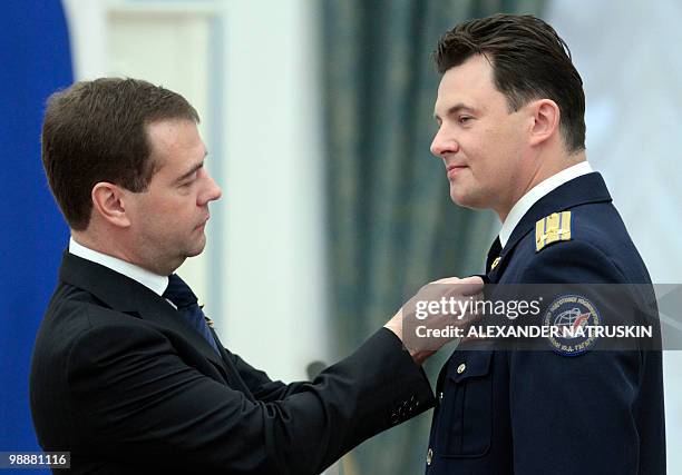 Russia's President Dmitry Medvedev decorates Roman Romanenko, a Russian cosmonaut, with the order Hero of Russia during an award ceremony in Moscow's...