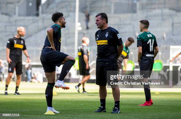 Headcoach Dieter Hecking talks to Keanan Bennetts during a training session of Borussia Moenchengladbach at Borussia-Park on July 01, 2018 in...
