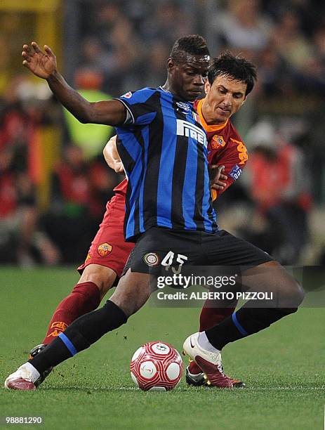 Inter Milan's forward Mario Balotelli fights for the ball with AS Roma's Argentine defender Nicolas Burdisso during the Coppa Italia final on May 5,...