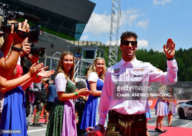 Red Bulls Australian driver Daniel Ricciardo wears traditional "Lederhosen" as he arrives prior to the Austrian Formula One Grand Prix in Spielberg,...