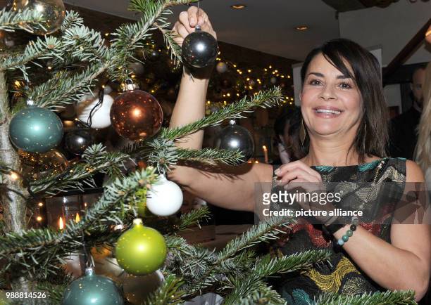 The model Gitta Saxx decorates a Christmas tree at the DKMS LIFE Charity Ladies Lunch in Munich, Germany, 12 December 2017. Photo: Ursula Düren/dpa