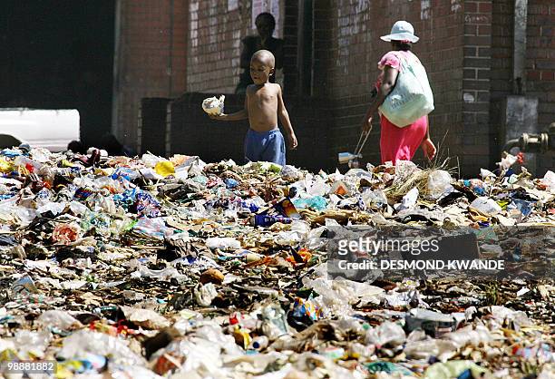 Young Zimbabwean boy plays on a heap of rubbish in Harare's Mbare surbub on May 6, 2010. Local authorites have not collected the garbage over the...
