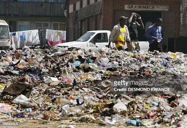 Zimbabwean walks past a heap of rubbish in Harare's Mbare surbub on May 6, 2010. Local authorites have not collected the garbage over the past few...