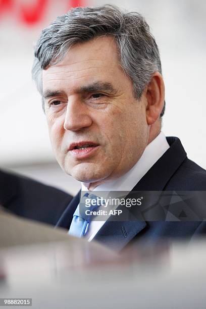 Britain's Prime Minister Gordon Brown talks with potential car buyers at a car dealership in north London, on May 18, 2009. The Government's "cash...