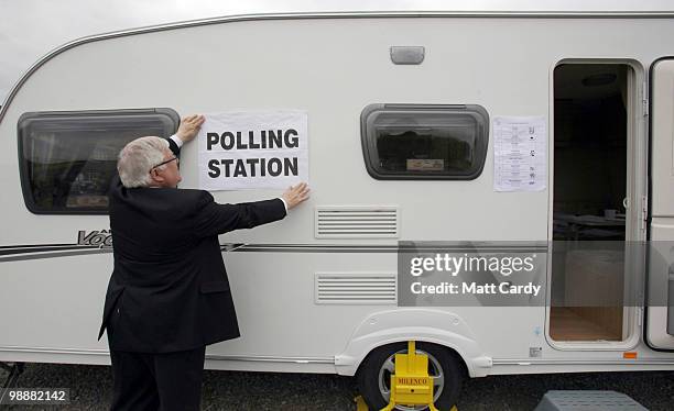 Andrew Hext, presiding officer adjust the polling station sign on a caravan being used as a polling station on May 6, 2010 in Ford near Salisbury,...