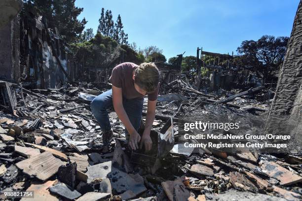 Jordan Williamson looks thorough a box he found in the rubble of his home that was destroyed in the Canyon Fire 2 in Anaheim, California, on Tuesday,...