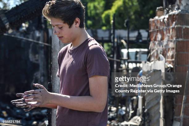 Jordan Williamson wipes the sooth from his hands after searching the remains of his home that was destroyed in the Canyon Fire 2 in Anaheim,...