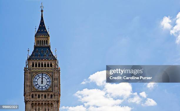 top of big ben in london against a blue sky - newpremiumuk stock-fotos und bilder