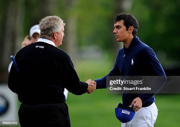 Matteo Manassero of Italy shakes hands with Ryder Cup captain Colin Montgomerie of Scotland on the nineth hole during the first round of the BMW...