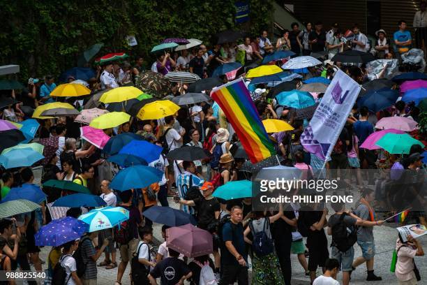 Activists use umbrellas to shelter from the rain as they gather in Civil Square outside the Central Government Complex after a protest march by...