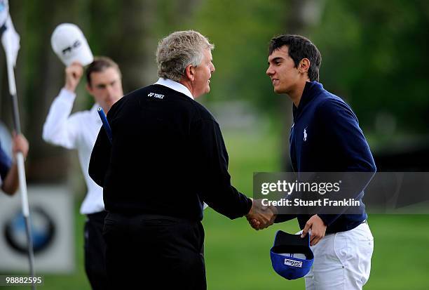 Matteo Manassero of Italy shakes hands with Ryder Cup captain Colin Montgomerie of Scotland on the nineth hole during the first round of the BMW...