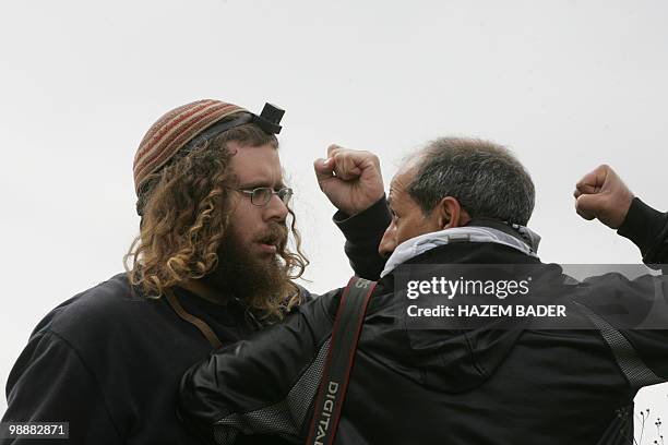 Jewish settler and a Palestinian photographer have a fist fight as Fatah movement members and supporters prepare to plant olive trees on occupied...