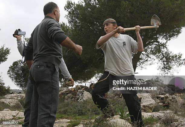 Jewish settler and a Palestinian man confront each other as settlers try to stop tens of Fatah movment members and supporters from planting olives...