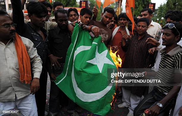 Viswa Hindu Parishad supporters burn a Pakistani flag to celebrate the death sentence of Mohammed Ajmal Amir Kasab in Allahabad on May 6, 2010. The...