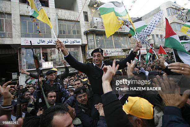 Member of the Palestinian security forces waves Fatah falgs during a march marking the 45th anniversary of the start of Fatah's armed struggle...