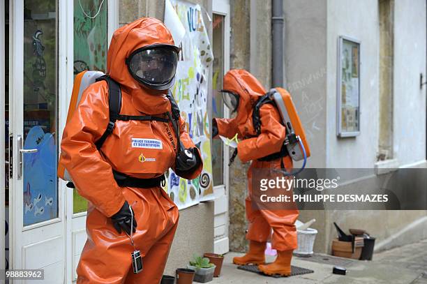 Two members of the scientific police wearing gas and liquid-proof jumpsuits gather evidence during a simulation of a chemical bomb attack on May 6,...