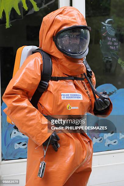 Member of the scientific police wearing gas and liquid-proof jumpsuits gathers evidence during a simulation of a chemical bomb attack on May 6, 2010...