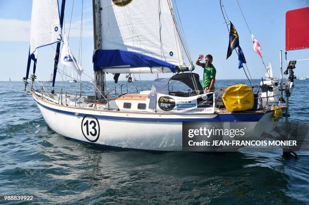 English born-Australian Kevin Farebrother on his boat "Sagarmatha" waves as he sets sail from Les Sables d'Olonne Harbour on July 1 at the start of...