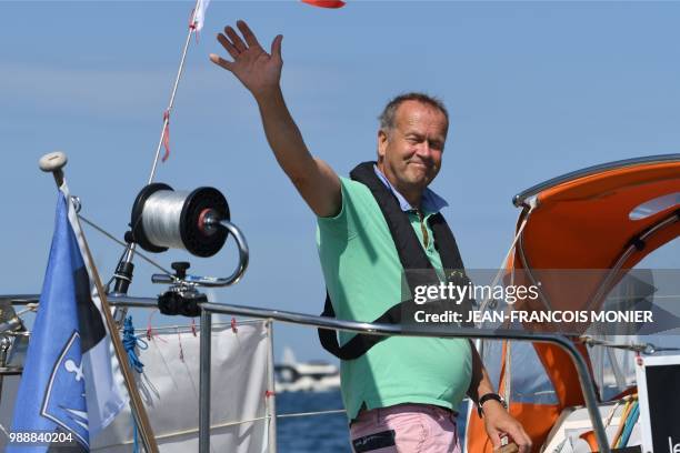 Estonian's Uku Randmaa waves on his boat "Rustler 36" as he sets sail from Les Sables d'Olonne Harbour on July 1 at the start of the solo...