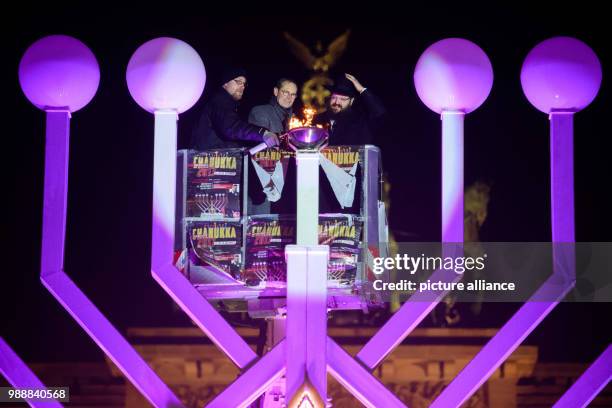 Rabbi Yehuda Teichtal and Berlin's ruling mayor Michael Mueller from the Social Democratic Party of Germany light the first light on the Hanukkah...